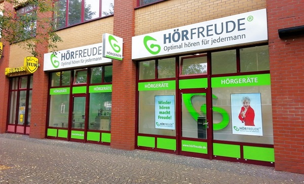 Fassade eines Hörgeräte-Fachgeschäfts mit grüner Beschriftung und großem HÖRFREUDE-Logo.